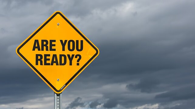 Yellow road warning sign with are you ready text against cloudy sky background concept
