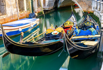 Obraz premium gondolas in venetian canal decorated in traditional vintage style of Venice and old architecture buildings on background