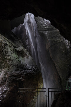 Cascate Varone waterfall in gorge with natural light illuminating rock walls in underground cave parco grotta Trentino Italy