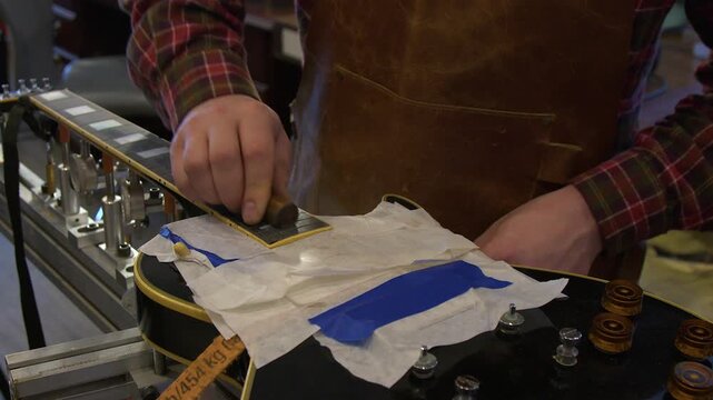 Guitar technician works refret job on classic vintage electric guitar