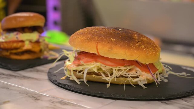 A close-up cinematic shot of a fresh toasted sub sandwich featuring melted cheese, meat, and shredded lettuce on a wooden board.