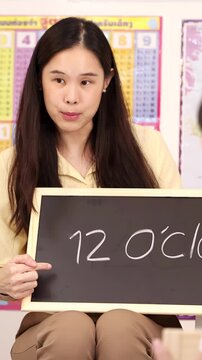 Smiling Teacher Teaching Kids to Read Twelve O&acirc;Clock Time