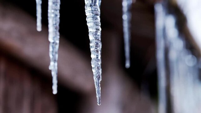 Beautiful icicles that look like crystals which have formed on a wooden cabin in the winter