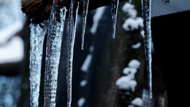 Impressive large icicle formation in extreme cold weather conditions in Europe with water dripping off the end as it slowly defrosts as the seasons change