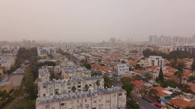 Holon city residential area during a thick Israeli sandstorm in Jessy Cohen with low visibility and dust particles.