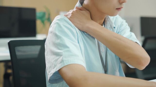 Tired businessman massages stiff neck, suffering from neck pain, shoulder pain from burnout, fibromyalgia and muscle inflammation. Overworked male employee feels discomfort, massages rubs sore muscles