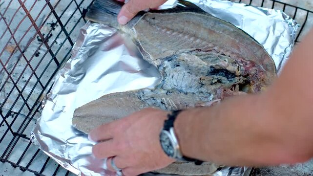 Butterflied Blackfish (black bream) placed on tinfoil on grid for barbecue