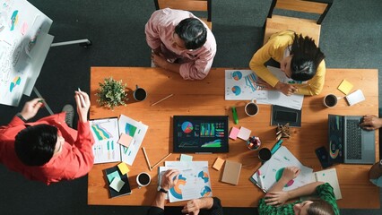 Fototapeta na wymiar Top view of attractive diverse team clapping hands while project manager present creative idea at meeting room. Diverse team working together planning marketing strategy at meeting room. Convocation.