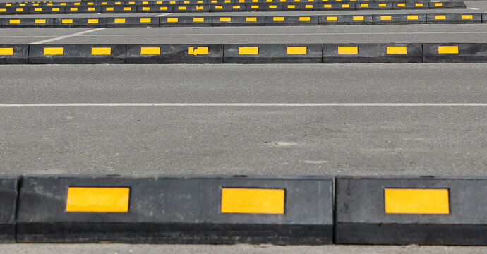 Huge Rubber Curbs In Lines For Correct Car Parking On Outdoor Asphalt Park Lot 