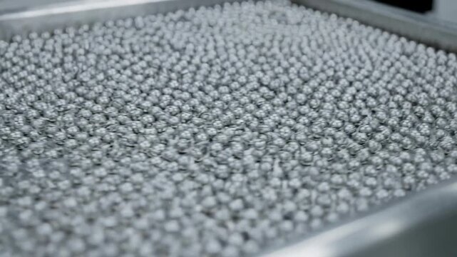 Medium view capturing uniform supported metal catalyst beads arranged methodically on a reactor tray highlighting industrial process precision.