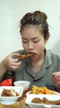 Young Asian woman eating food at home