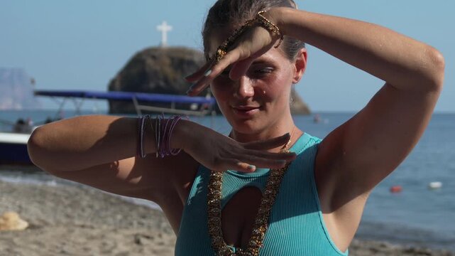 Woman, dance, beach, beautiful young woman performing traditional Indian dance mudras on a sunny seashore