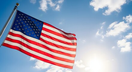 Obraz premium American flag waving in the wind against a bright blue sky