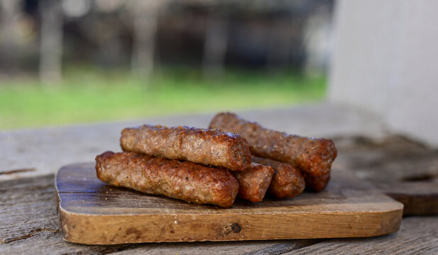 Grilled  meal on barbeque. on  wooden Background.  Small sausages from minced meat, a very popular dish in the Balkan countries. 