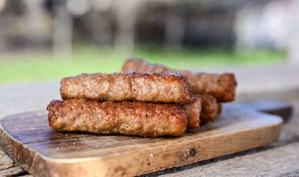 Grilled  meal on barbeque. on  wooden Background.  Small sausages from minced meat, a very popular dish in the Balkan countries. 