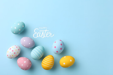 Fototapeta premium Minimal Easter composition with pastel eggs on blue background. Clean spring holiday greeting template.