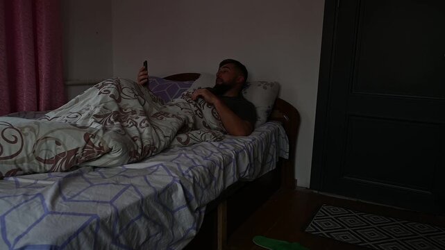 A man wakes up and checks the news and mail on his phone, the morning starts with the phone.