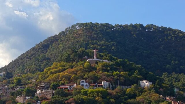Aerial view dolly in panorama of Atachi Hill in Taxco de Alarcon with the Monumental Christ of Taxco, Guerrero, Mexico