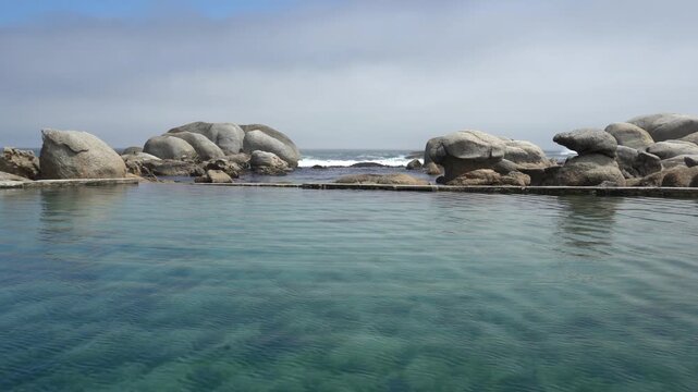 Rocky shoreline crashing waves by the tidal pool