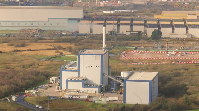 Industrial biomass energy facility converting recycled wood waste and timber scraps into clean electricity. Sustainable infrastructure and green energy production at a modern power station.