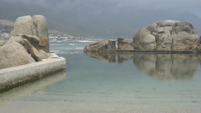 Crashing waves between huge boulders washing into the tidal pool
