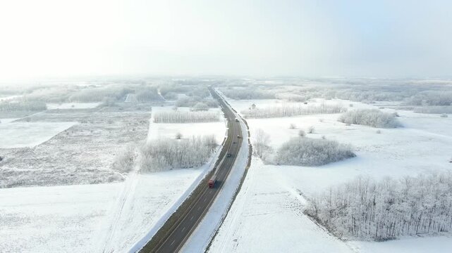 Cars driving on a snowy detour road around the city of Soltvadkert, Hungary in aerial view on winter day