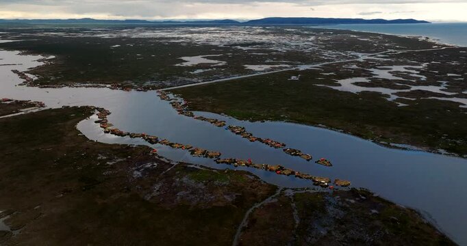 Aerial orbit overview of Uros floating islands on Lake Titicaca near Puno Peru, overcast soft sky