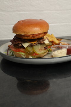 Hamburger avec l&eacute;gumes et frites bien pr&eacute;sent&eacute;s