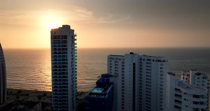 Aerial sunset view over ocean behind tall buildings of Bocagrande in Cartagena