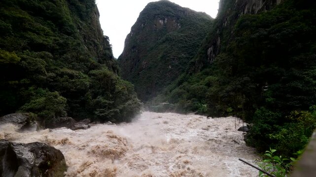 Urubamba River Flowing Rapidly Past During Rainy Season In Aguas Calientes At The Base Of Machu Picchu In Peru. Slow Motion Shot