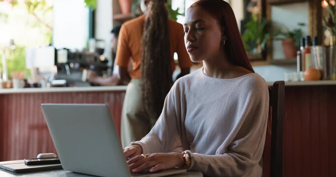 Laptop, remote work and woman typing in coffee shop for newsletter, blog and copywriting on website. Computer, cafe and freelance copywriter with email for research, review article or lead magnet