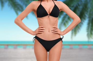 Fototapeta premium Woman with beautiful fit body on beach, closeup