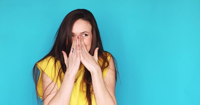 Surprised young woman pointing at herself in disbelief, feeling happy and shocked by unexpected good news, smiling and laughing standing isolated on blue background. Concept of win and success