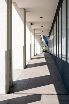 Modern architecture corridor walkway with colonnade perspective lines and repeating shadow light creating an abstract background with clean structure