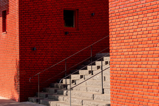 Red brick stairs with handrail in urban modern minimal architecture using abstract geometry to express progress and overcome mindset through clean design