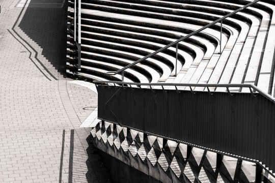 Abstract modern stairs with railing and shadow pattern in strong contrast using geometry to show progress and overcome challenge through minimal design