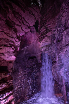 waterfall with purple light rock textures underground cave cascate del varone parco grotta trentino alto adige italy