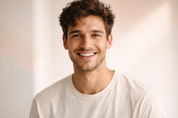 Fototapeta premium Young man with curly brown hair and a bright white smile looking directly at the camera