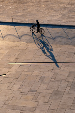 Shadow of a cyclist on pavement in Oslo Norway showing urban mobility and commuting with long sunlight and minimal street geometry