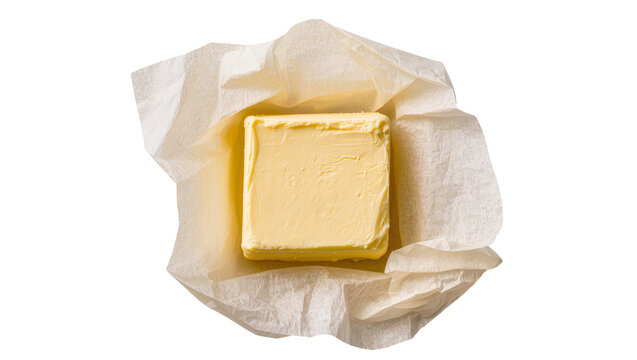 Isolated block of fresh butter partially unwrapped in parchment paper for cooking and baking