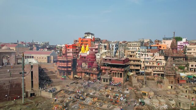 Aerial view of Varanasi cremation ghat with Ganges river and burning rituals.