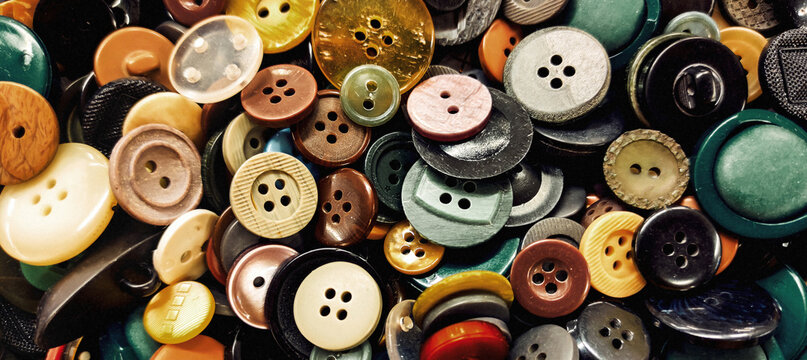 Banner close-up photo with a pile of colorful sewing buttons. Suitable for sewing, tailoring supplies, haberdashery, dressmaking and craft themes.