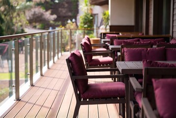 Fototapeta premium A wooden deck with outdoor seating and tables, suggesting a restaurant or patio area.