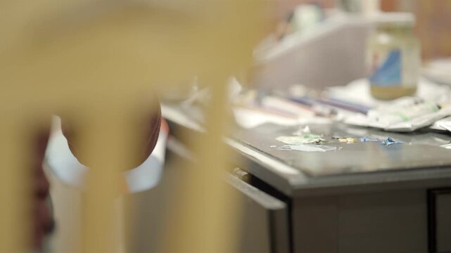 Artist hand painting on canvas with flat brush in studio close up shot
