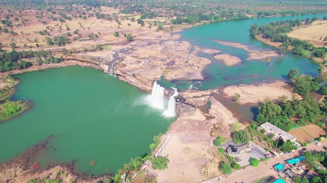 Cinematic drone reveal of Chitrakote Waterfall with river and surrounding landscape.