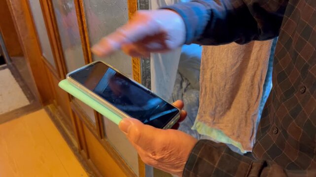 スマートフォンを操作する高齢者