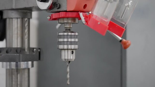 Close-up of a spinning workshop drill press with rotating bit and precision machinery detail, ideal for industrial, engineering, manufacturing, metalwork and process concepts