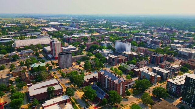 A sweeping aerial view capturing the dense architecture of University of Illinois campus, including residential halls and sports facilities, surrounded by greenery.