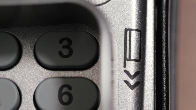 Top down close up of credit card swiped through bank terminal reader