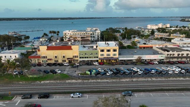 A sweeping drone view reveals the small-town charm of downtown Stuart surrounded by tropical greenery and waterfront scenery.
